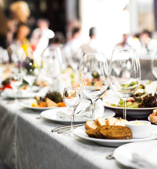 Sparkling glassware stands on long table prepared for wedding dinner